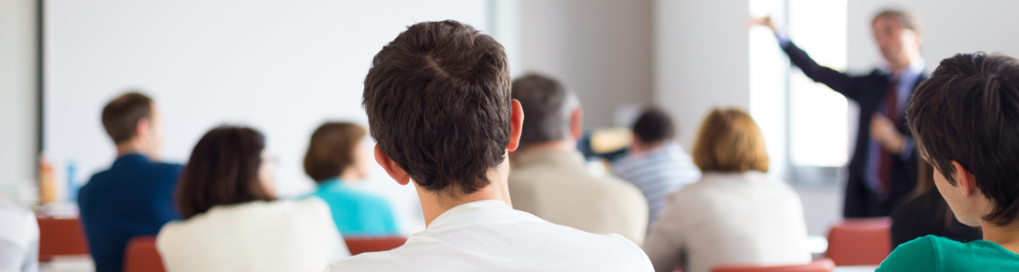 Students listening to a presenter in front of classroom